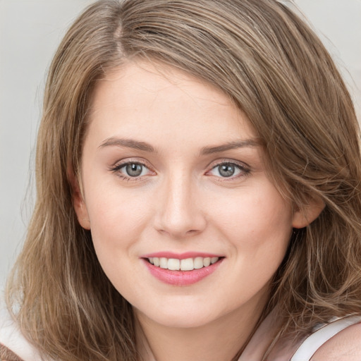 Joyful white young-adult female with long  brown hair and blue eyes