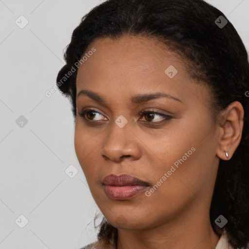 Joyful black young-adult female with long  black hair and brown eyes