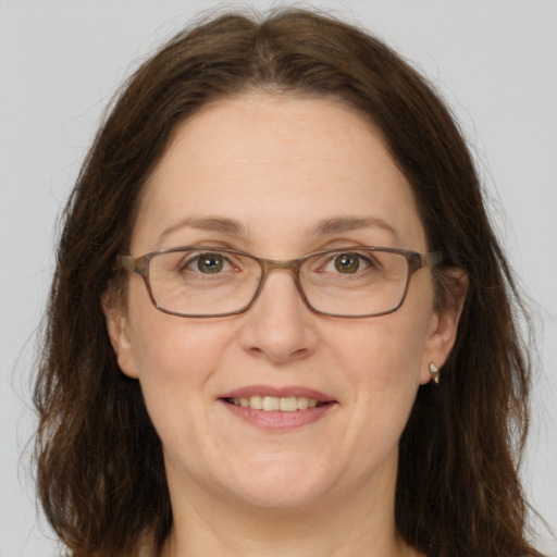 Joyful white adult female with long  brown hair and grey eyes