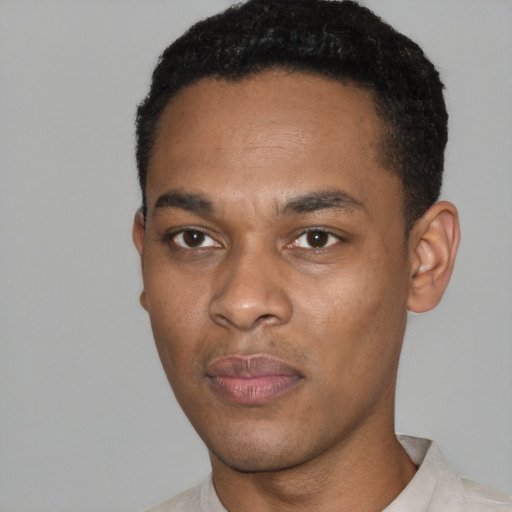 Joyful black young-adult male with short  black hair and brown eyes