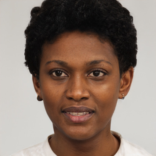 Joyful black young-adult female with short  black hair and brown eyes