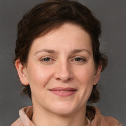 Joyful white adult female with medium  brown hair and grey eyes