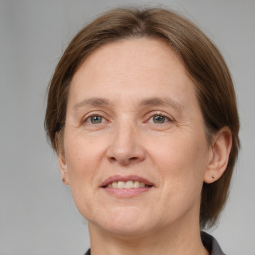 Joyful white adult female with medium  brown hair and grey eyes