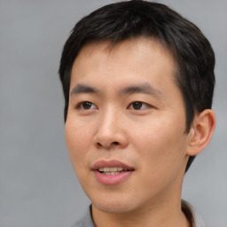 Joyful asian young-adult male with short  brown hair and brown eyes