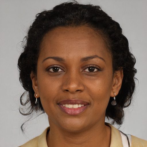 Joyful black young-adult female with medium  brown hair and brown eyes