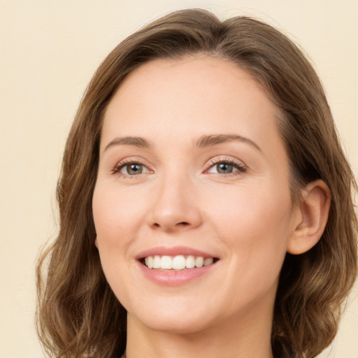 Joyful white young-adult female with long  brown hair and green eyes