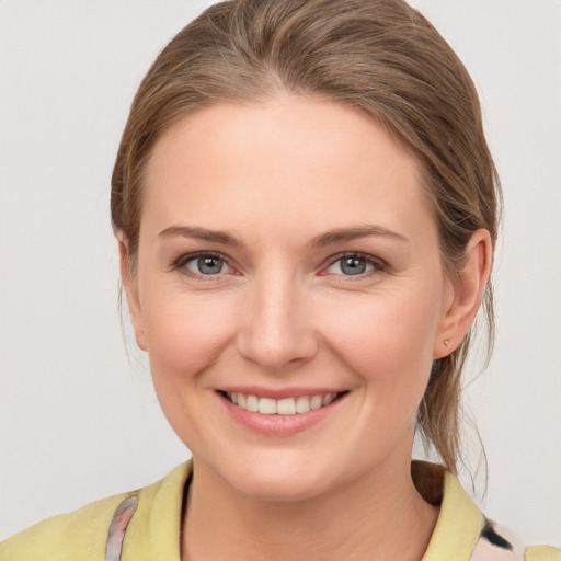 Joyful white young-adult female with medium  brown hair and grey eyes