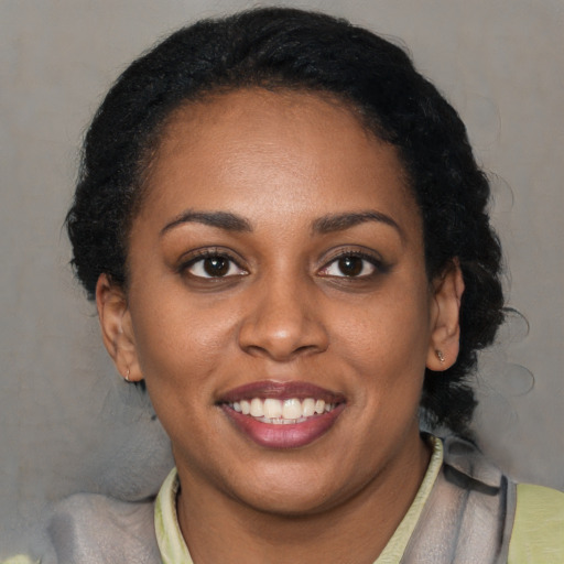 Joyful black young-adult female with short  brown hair and brown eyes