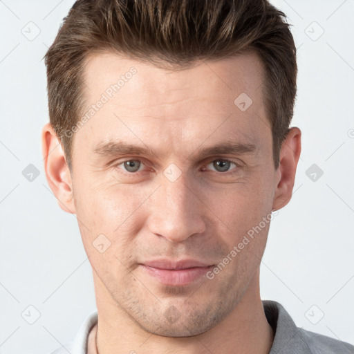 Joyful white young-adult male with short  brown hair and grey eyes