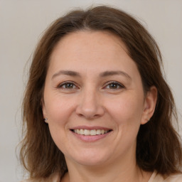 Joyful white adult female with medium  brown hair and grey eyes