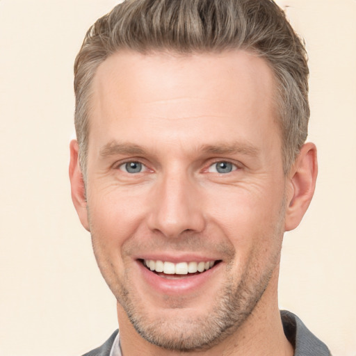 Joyful white young-adult male with short  brown hair and grey eyes