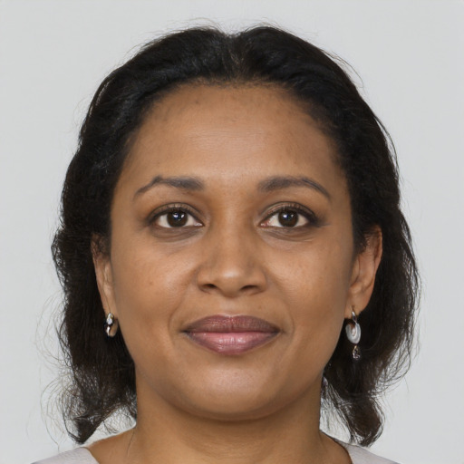 Joyful black adult female with medium  brown hair and brown eyes
