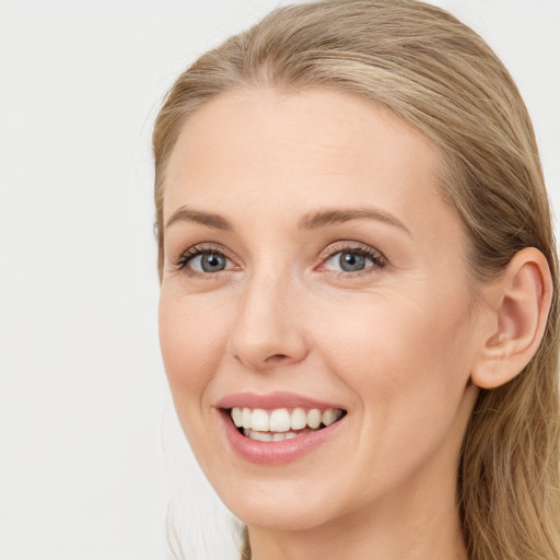 Joyful white young-adult female with long  brown hair and blue eyes