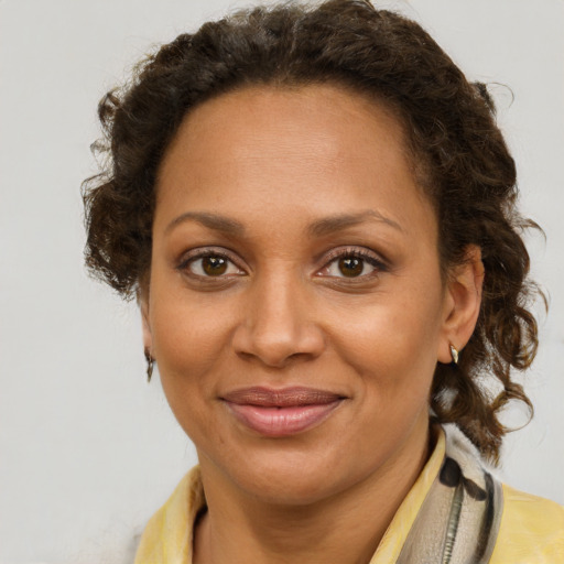 Joyful black adult female with short  brown hair and brown eyes