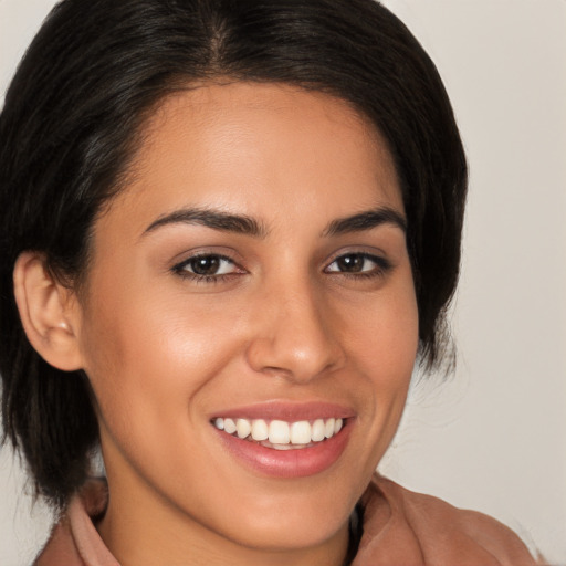 Joyful latino young-adult female with medium  brown hair and brown eyes