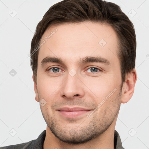 Joyful white young-adult male with short  brown hair and grey eyes