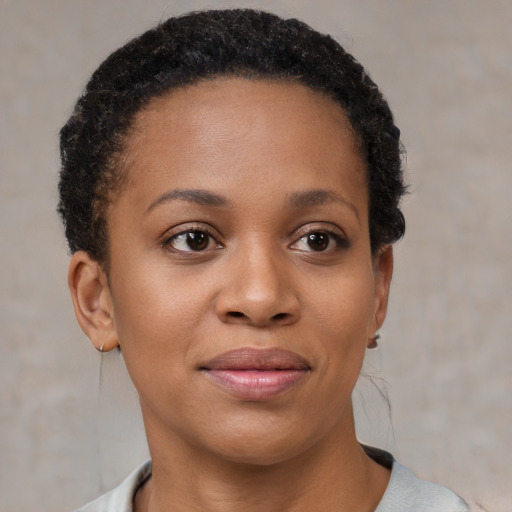Joyful black young-adult female with short  brown hair and brown eyes