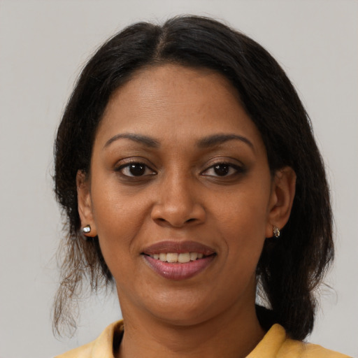 Joyful black adult female with medium  brown hair and brown eyes