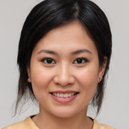 Joyful asian young-adult female with medium  brown hair and brown eyes