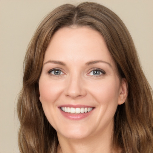 Joyful white young-adult female with long  brown hair and green eyes