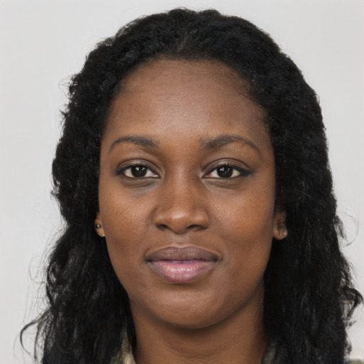 Joyful black young-adult female with long  black hair and brown eyes