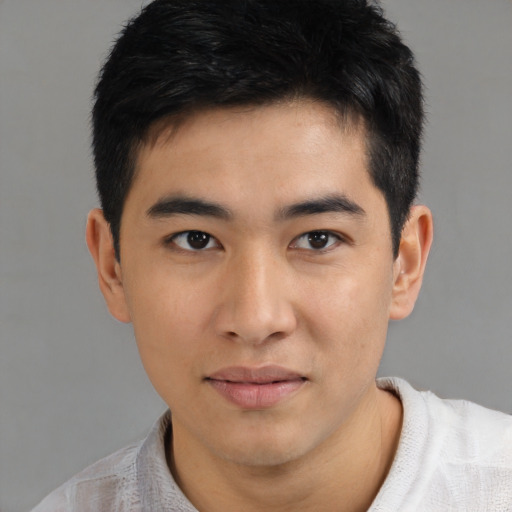Joyful asian young-adult male with short  black hair and brown eyes