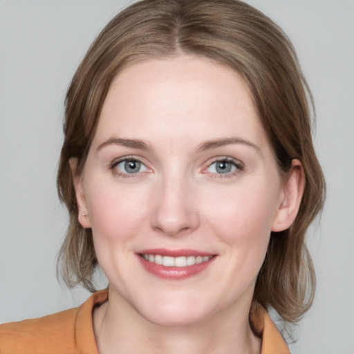 Joyful white young-adult female with medium  brown hair and blue eyes