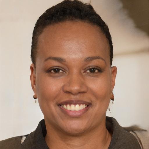 Joyful black young-adult female with short  brown hair and brown eyes