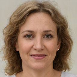 Joyful white adult female with medium  brown hair and green eyes