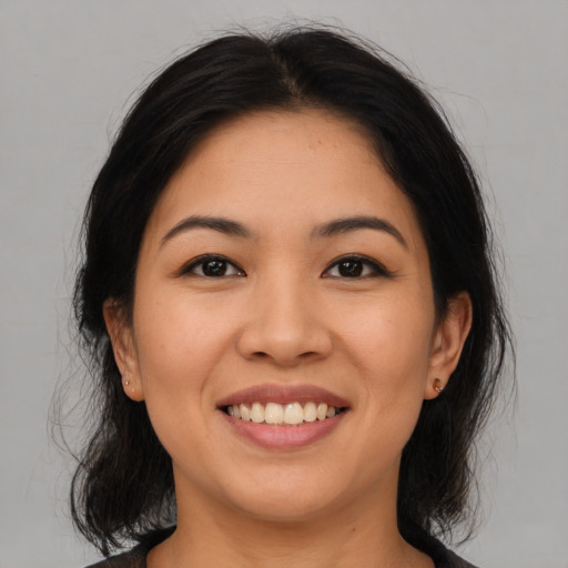 Joyful asian young-adult female with medium  black hair and brown eyes