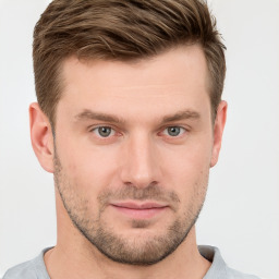 Joyful white young-adult male with short  brown hair and grey eyes