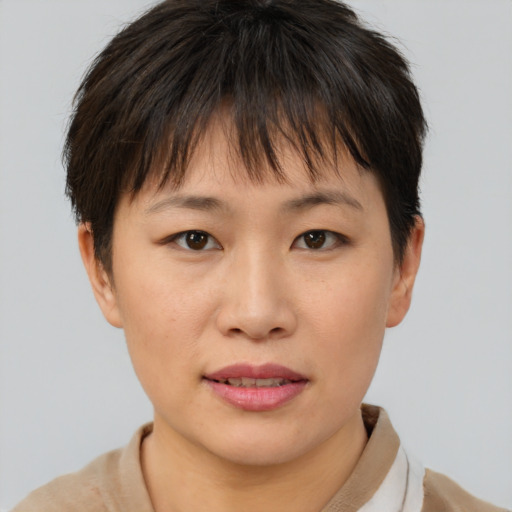 Joyful asian young-adult female with short  brown hair and brown eyes