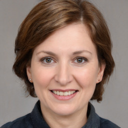 Joyful white adult female with medium  brown hair and grey eyes