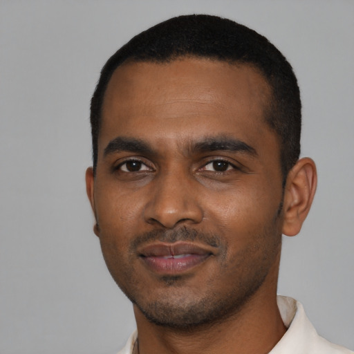 Joyful black young-adult male with short  black hair and brown eyes