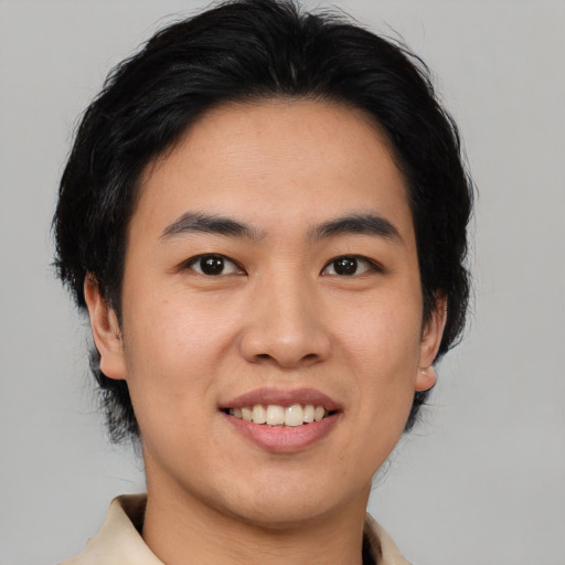 Joyful asian young-adult male with medium  brown hair and brown eyes