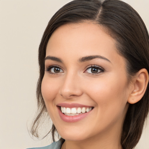 Joyful white young-adult female with long  brown hair and brown eyes