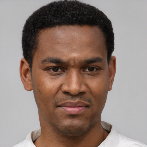 Joyful black young-adult male with short  black hair and brown eyes