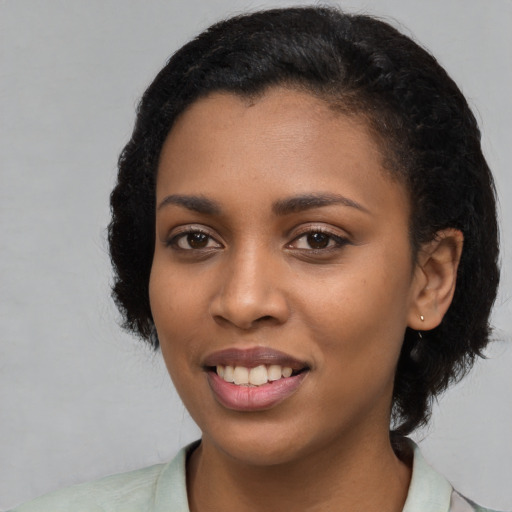 Joyful black young-adult female with medium  black hair and brown eyes