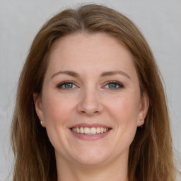 Joyful white young-adult female with long  brown hair and grey eyes