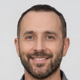 Joyful white adult male with short  brown hair and brown eyes