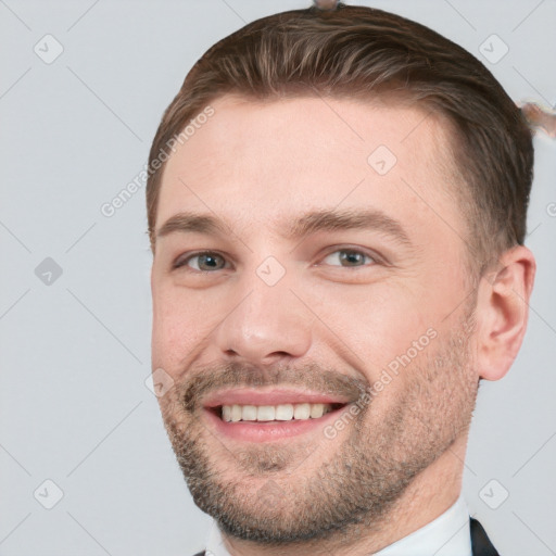 Joyful white young-adult male with short  brown hair and grey eyes