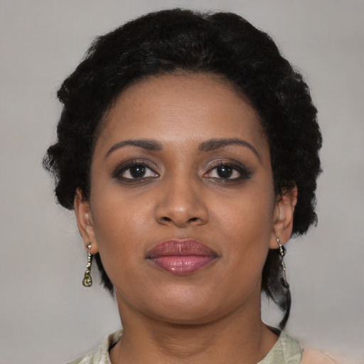 Joyful black young-adult female with short  black hair and brown eyes