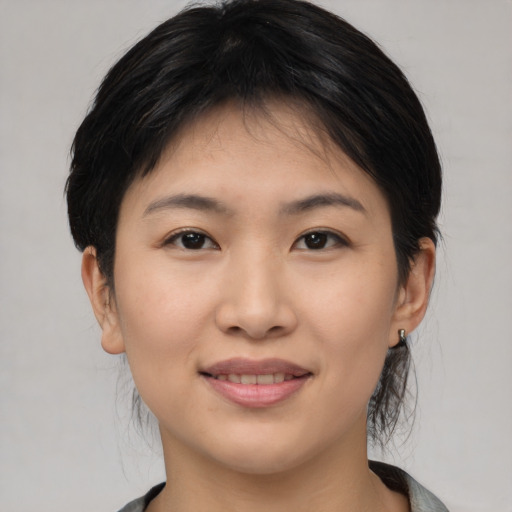 Joyful asian young-adult female with medium  brown hair and brown eyes