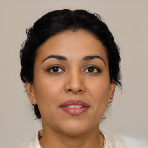 Joyful latino adult female with medium  brown hair and brown eyes