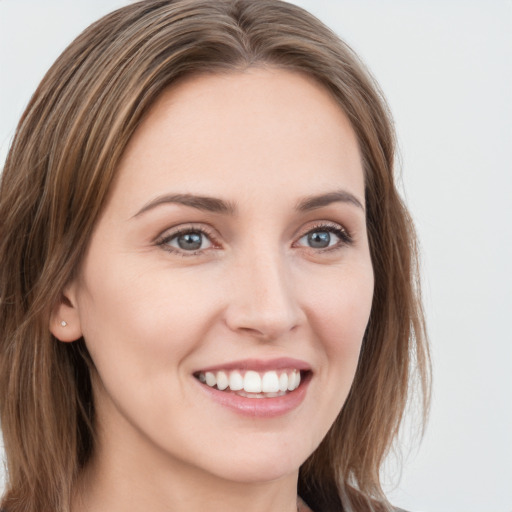 Joyful white young-adult female with long  brown hair and blue eyes