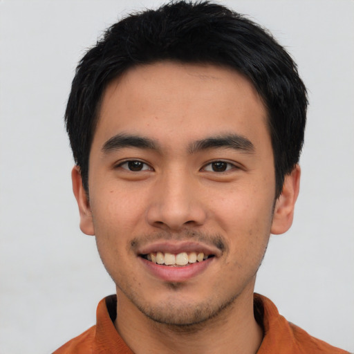 Joyful asian young-adult male with short  black hair and brown eyes