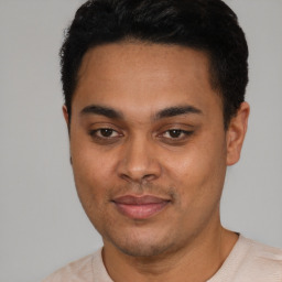 Joyful latino young-adult male with short  black hair and brown eyes