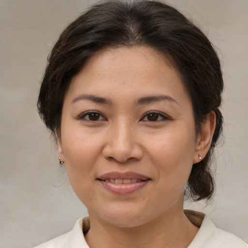 Joyful asian adult female with medium  brown hair and brown eyes
