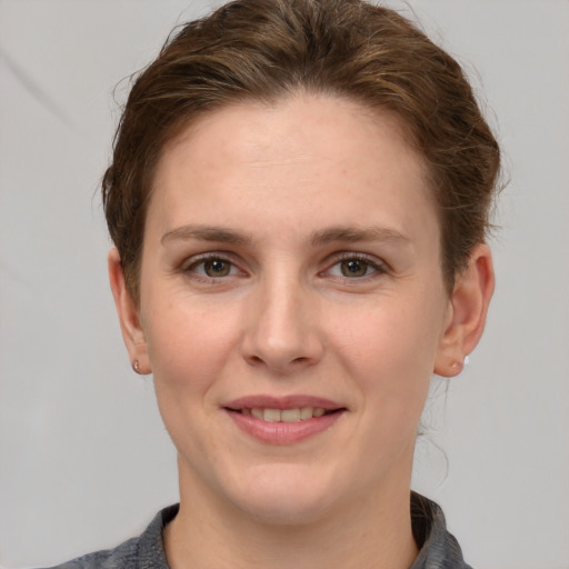 Joyful white young-adult female with short  brown hair and grey eyes