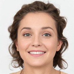 Joyful white young-adult female with medium  brown hair and blue eyes